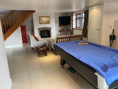 a bedroom with a bed and a living room with a fireplace at The little house in West Hanningfield