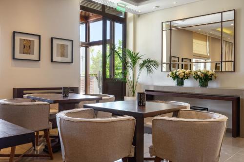 a restaurant with tables and chairs and a mirror at Ayia Marina Suites in Ouranoupoli