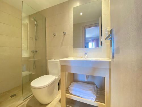 een badkamer met een toilet, een wastafel en een douche bij Louvre Hotel in Gouvia