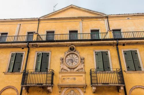 a building with a clock on the side of it at Hotel Colomba d'Oro in Verona