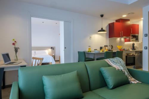 a living room with a green couch and a kitchen at Tgna Reial 1 in Tarragona