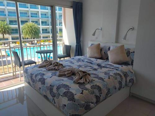 a bedroom with a bed with a view of a pool at Grandbeach 1 condo A202 in Rayong