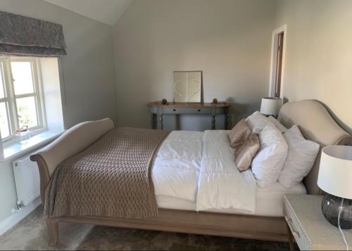 1 dormitorio con 1 cama con sábanas y almohadas blancas en Church View Cottage, Drift House Holiday Cottages en Congleton