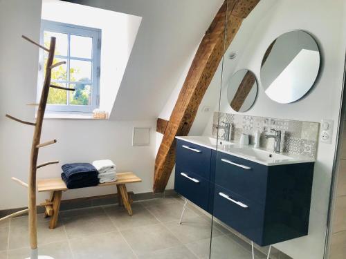 bagno con lavandino blu e specchio di Les Chambres de La Varenne a La Flèche