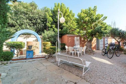 a garden with a bench and a table and chairs at Gava Ocean View in Gavà