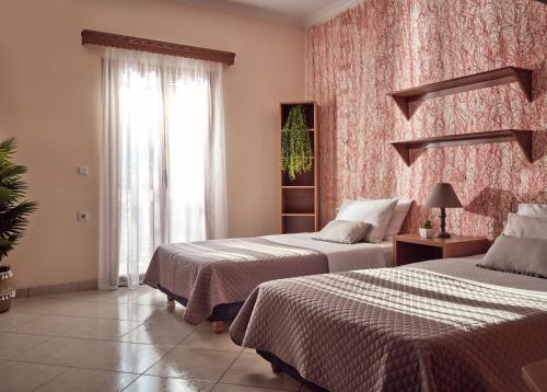 a hotel room with two beds and a window at Lithakia Balcony Villa - Private Pool, Large Groups & Sea View, by ZanteWize in Lithakia