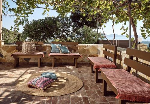 a patio with benches and pillows and a table at Lithakia Balcony Villa - Private Pool, Large Groups & Sea View, by ZanteWize in Lithakia