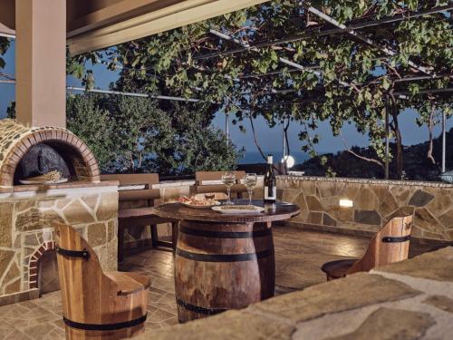 a patio with a table with a wine bottle at Lithakia Balcony Villa - Private Pool, Large Groups & Sea View, by ZanteWize in Lithakia
