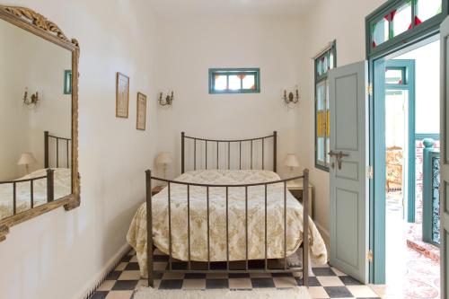 Schlafzimmer mit einem Bett und einem Spiegel in der Unterkunft Aghata Palms Riad in Essaouira