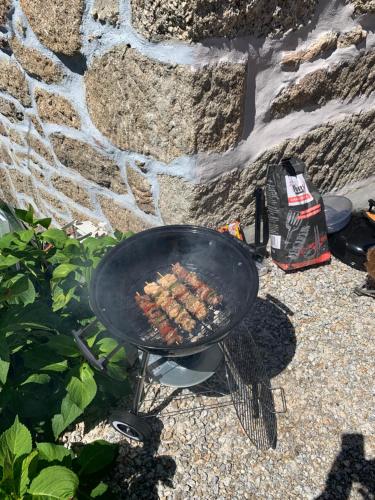 una parrilla con un montón de comida cocinando en ella en CASA DO PENEDO - Um Segredo na Serra da Estrela en Quintãs de Baixo