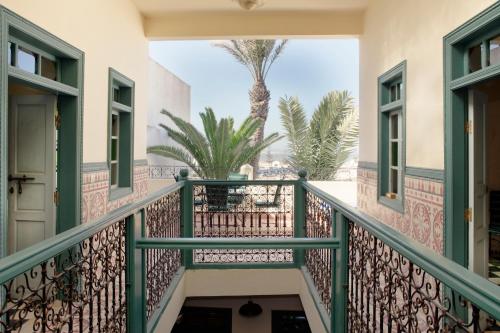 a balcony with palm trees in the background at Aghata Palms Riad in Essaouira