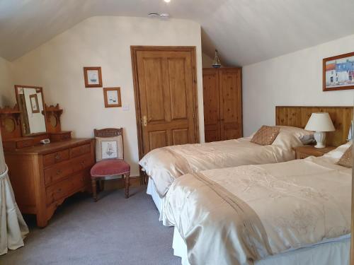 1 dormitorio con 2 camas, tocador y espejo en The Coach House Holiday Cottage, Southport, en Southport