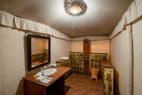 a bathroom with a sink and a mirror at Jungle Cave Resort in Sawāi Mādhopur