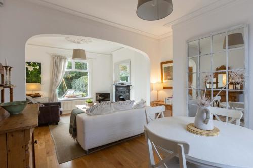 een woonkamer met een bank en een tafel bij Beersbridge Cottage near Titanic Centre & Airport in Belfast