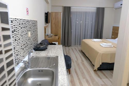 Siba Pamukkale Life في دنيزلي: غرفة في الفندق مع حوض وسرير