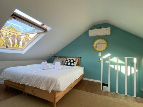 a bedroom with a bed with a blue wall and a window at Belém Fantastic Triplex House in Lisbon
