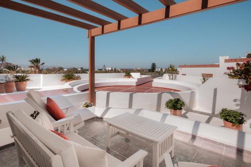 a patio with a table and chairs on a roof at Porto Naxos in Naxos Chora