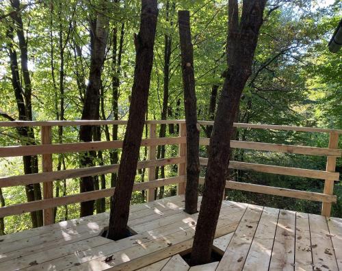 a wooden deck with trees and a fence at Kerca Bio Farm in Kercaszomor