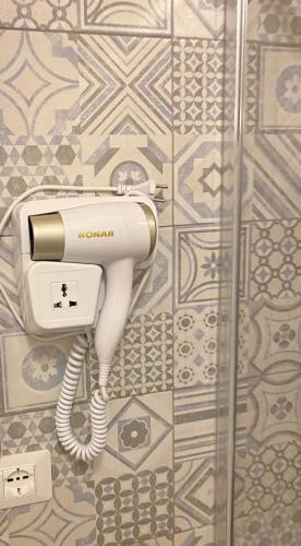 a phone hanging on a wall in a bathroom at ALMA B&B Home Cosenza in Cosenza