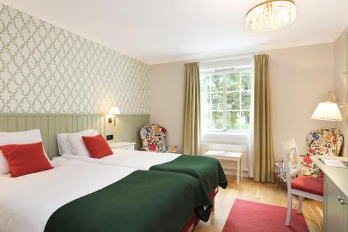 a hotel room with two beds and a window at Ronnums Herrgård in Vargön