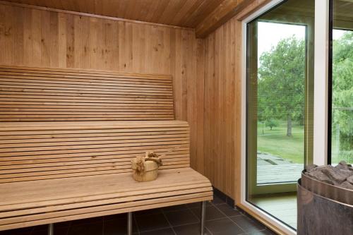 a wooden bench in a sauna with a window at Ronnums Herrgård in Vargön