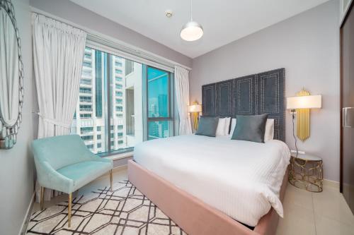 une chambre avec un grand lit et une grande fenêtre dans l'établissement BellaVista - Sophisticated - 2 BR - 29 Boulevard - Burj Khalifa & Fountain View, à Dubaï