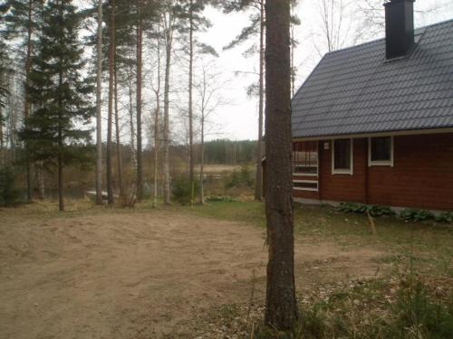 una casa en el bosque al lado de un árbol en Arvola, en Karstula