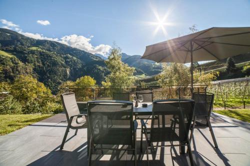 a table and chairs with an umbrella on a patio at Chalet Riad in Saltusio
