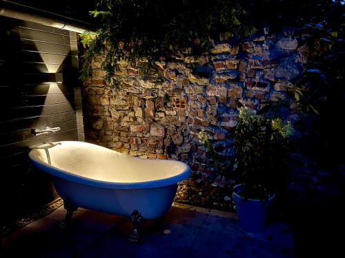 a blue bath tub sitting in front of a stone wall at Tiny House de Eikhof in Hengelo