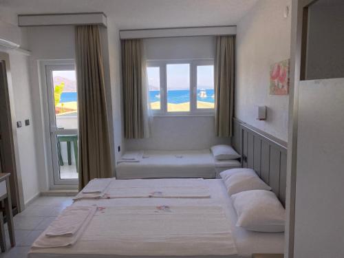 トゥルンチュにあるHotel Turunç-Malmenのベッドが3つと窓のある部屋