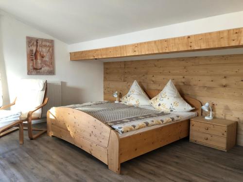 a bedroom with a bed with a wooden wall at Landhaus Hochgern in Unterwössen
