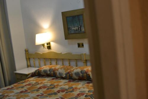 a bedroom with a bed and a table with a lamp at Hotel Cervantes in Mendoza