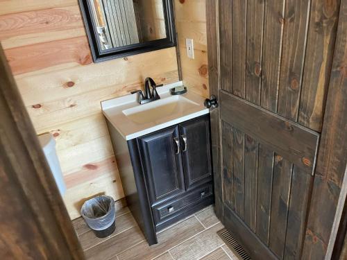a bathroom with a sink and a wooden door at Chalet Village- Amazing Mountain Views - Piney Butt Place in Gatlinburg