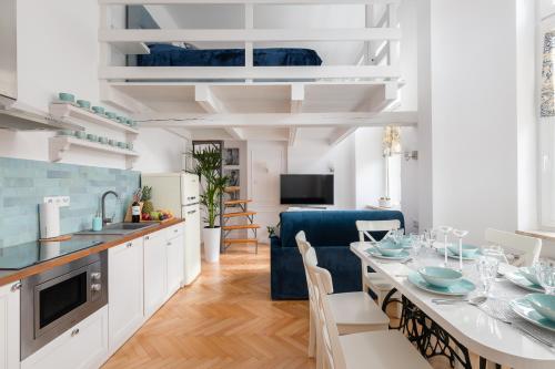 a kitchen and dining room with a table and a blue chair at Apartament Królewska by Your Freedom in Warsaw