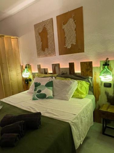 a bedroom with a bed with green sheets and pillows at Casa Lilla&Fabry Olbia in Olbia
