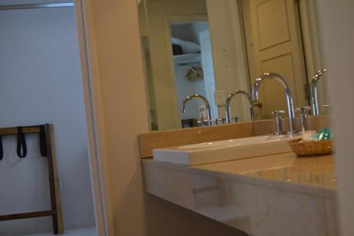 a bathroom with two sinks and a large mirror at Hotel Cervantes in Mendoza