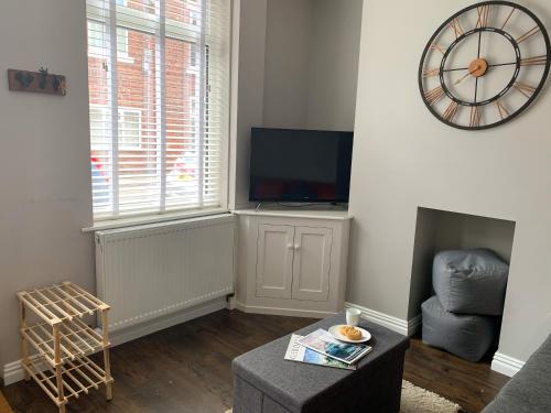 a living room with a tv and a chair at The Kensingston - Quaint Victorian Home With Free Parking in York