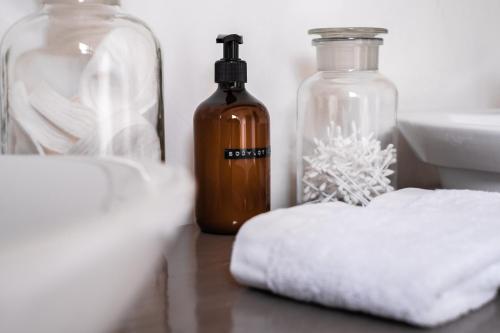 a bottle of soap sitting next to a pile of towels at Les Jardins de Jeanne in Middelkerke