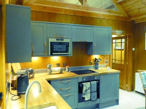 a kitchen with blue cabinets and a counter top at Wildcat Lodge in Boat of Garten