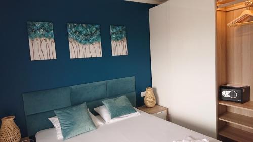 een slaapkamer met blauwe muren en een bed met 2 kussens bij SunsetCroatia in Novalja