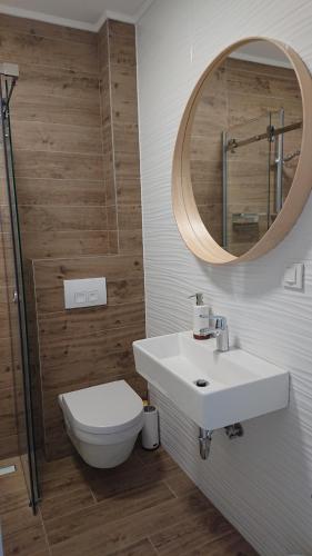 een badkamer met een toilet, een wastafel en een spiegel bij SunsetCroatia in Novalja