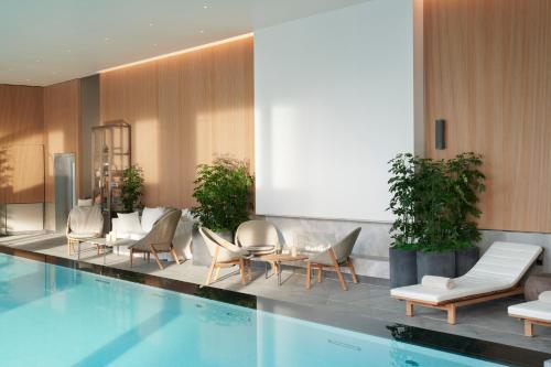 a hotel lobby with a swimming pool and chairs at Pan Pacific London in London
