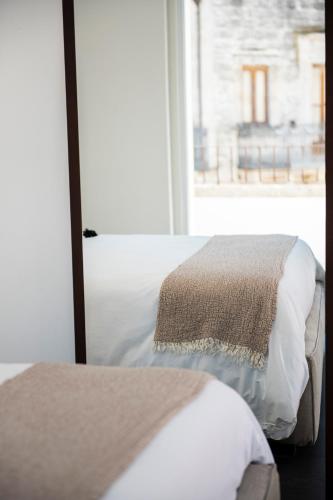 two beds in a room with a window at Arya Nobile Dimora in Carovigno