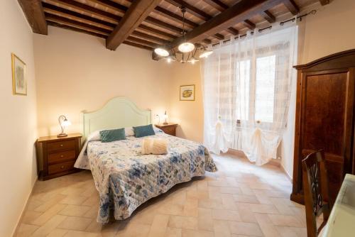 ein Schlafzimmer mit einem Bett und einem großen Fenster in der Unterkunft Albergo La Loggia di San Martino in Gualdo Tadino