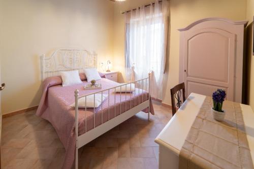 a bedroom with a bed and a table and a window at Albergo La Loggia di San Martino in Gualdo Tadino