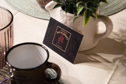 a table with a cup of coffee and a potted plant at Albergo La Loggia di San Martino in Gualdo Tadino