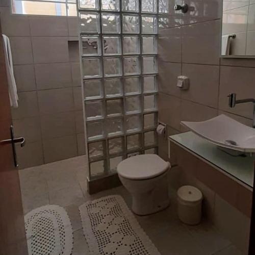 a small bathroom with a toilet and a sink at Apto Tranquilo e Aconchegante no Centro de Águas de Lindoia in Águas de Lindóia