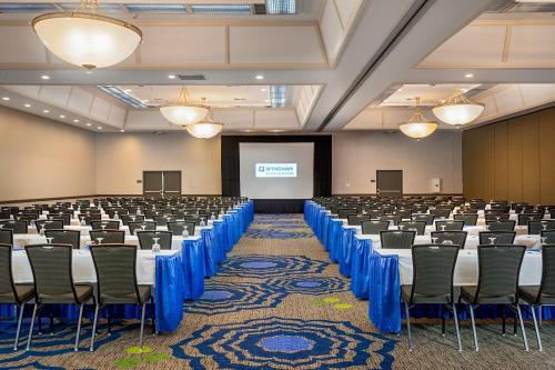 a conference room with tables and chairs and a screen at Wyndham San Diego Bayside in San Diego