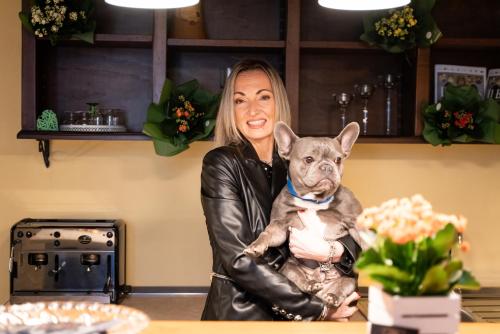 a woman in a leather jacket holding a dog at Albergo La Loggia di San Martino in Gualdo Tadino