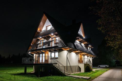 a large house with a gambrel roof at night at Stylovy in Białka Tatrzanska